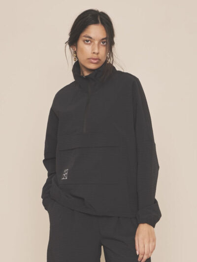 Woman wearing a black lightweight relaxed-sport style jacket with matching black lightweight pants