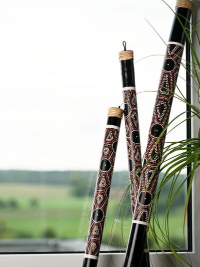Decorative didgeridoos near a window