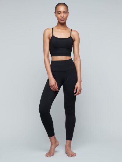 Yogini wearing black high-waisted shaping leggings and matching thin-strap bra.