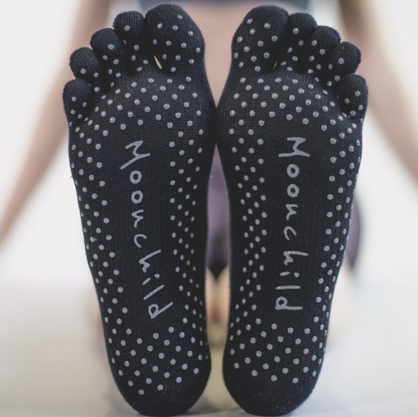 2 pieds chaussés de chaussettes aux semelles antidérapantes pour le pilates et le yoga avec orteils séparés