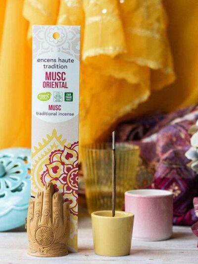 Incense pack in a frame decorated with candles, flowers, and incense sticks.