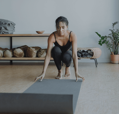 Femme déroulant un tapis pour séance de yoga