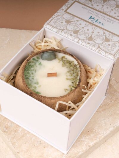 Candle in a coconut shell with dried flower petals and gemstones, presented in a pretty cardboard box