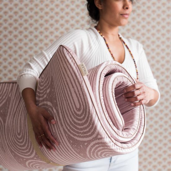 Woman carrying a pink yoga mat