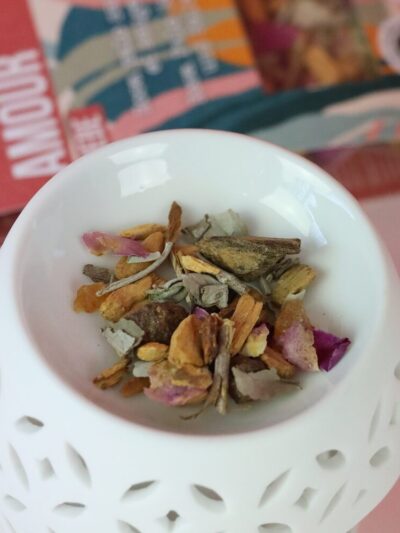 Blend of dried plants and flowers placed on a white porcelain incense diffuser