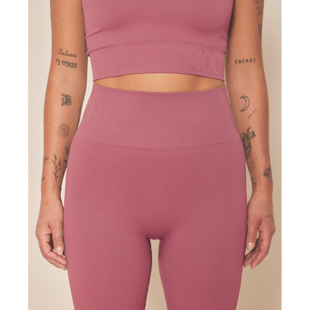 femme qui porte un legging et une brassière rose
