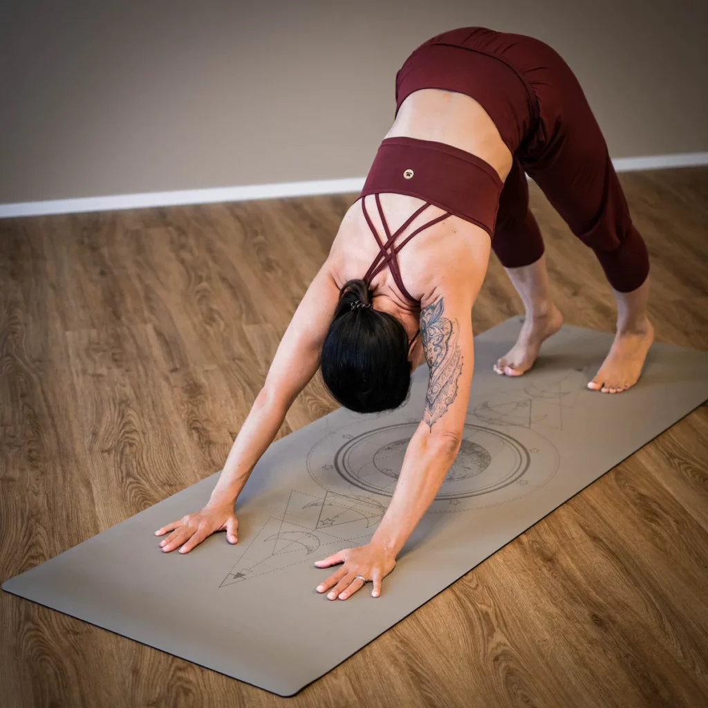 Femme faisant du yoga sur tapis gris