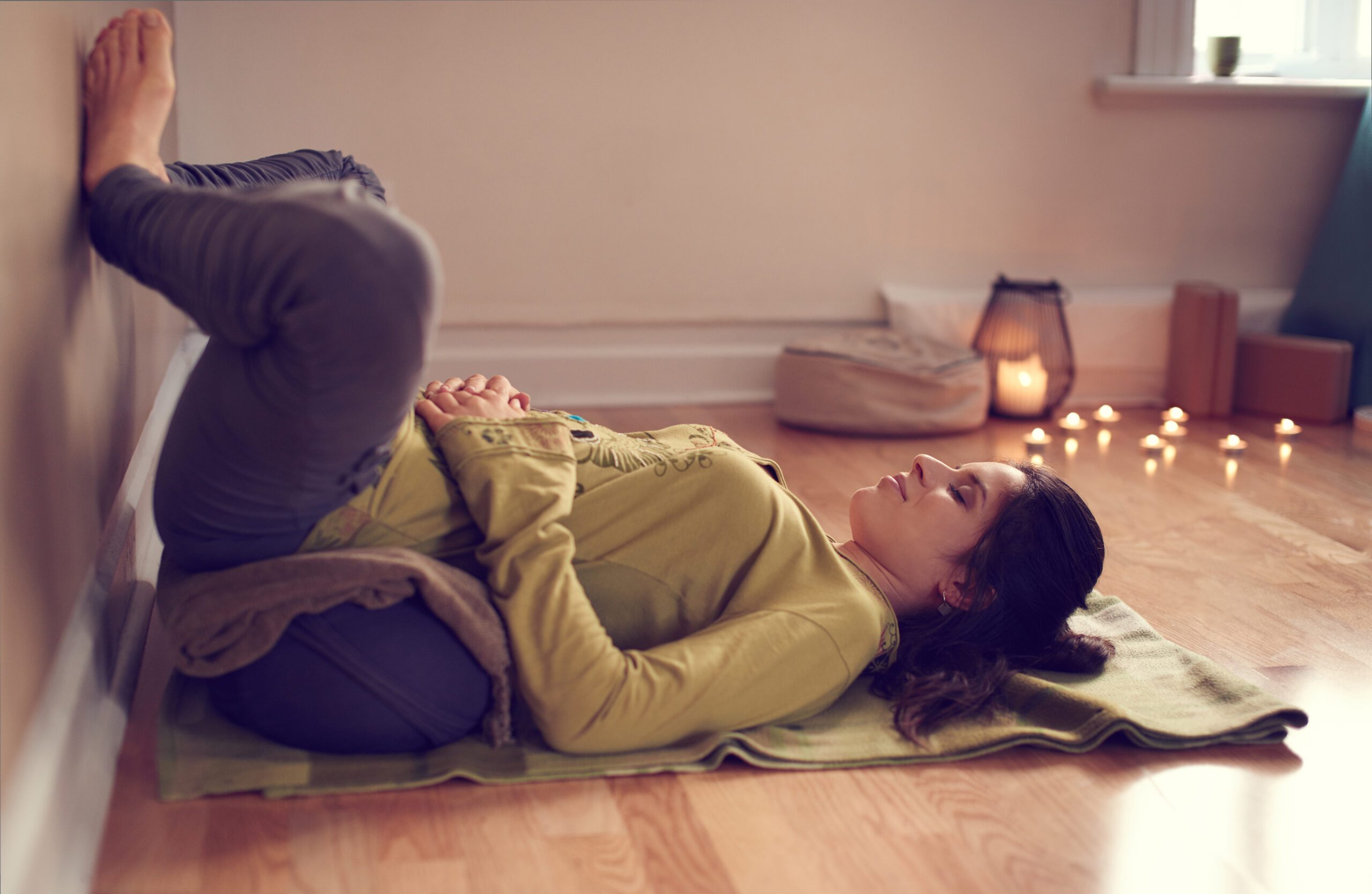 Female yoga practitioner using a bolster in a relaxation pose