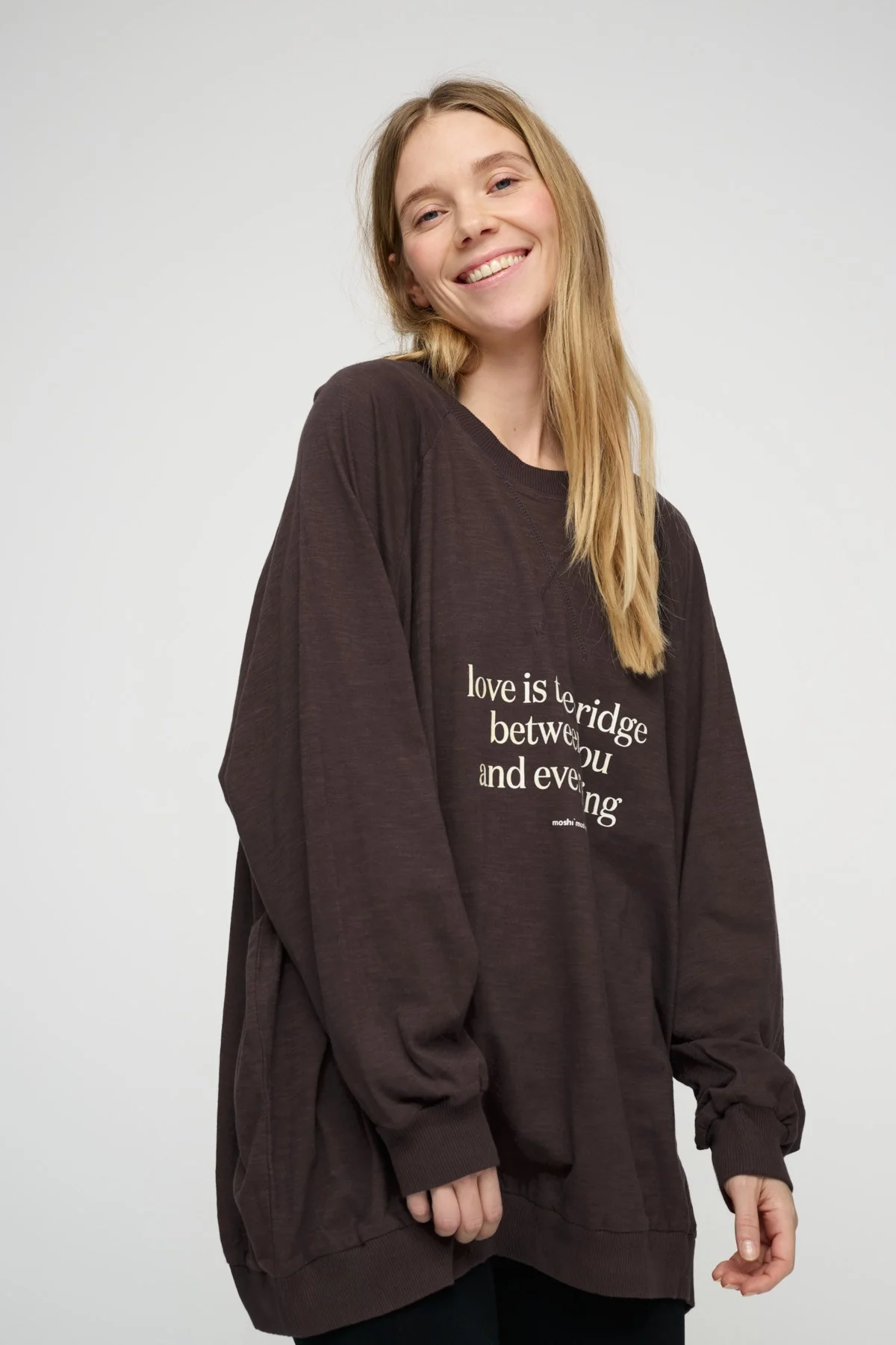 Smiling woman wearing a brown message sweatshirt