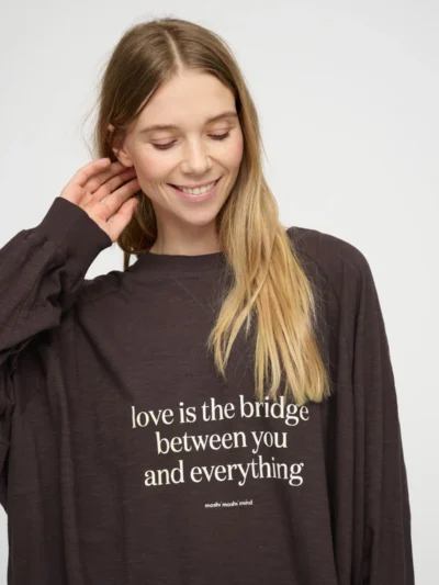 Smiling woman wearing a brown message sweatshirt