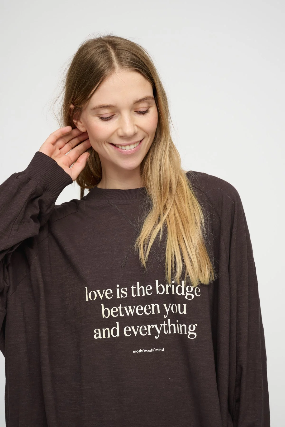 Smiling woman wearing a brown message sweatshirt