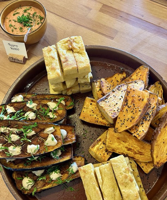 A large plate of roasted veggies and focaccia