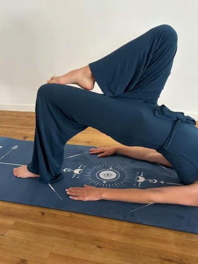 Woman doing a one-foot bridge pilates on a patterned blue mat